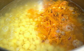 В кастрюлю с бобами сложите картофельные кубики. Залейте водой и поставьте на средний нагрев. Забросьте подрумяненные овощи.