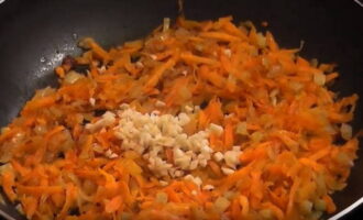 На любой терку измельчите морковь. Лук нарежьте кубиками, а чеснок просто порубите ножом. В сковородке разогрейте немного растительного масла и в нем обжарьте измельченные лук с морковью до легкого румяного цвета. Добавьте нарубленный чеснок, перемешайте и через 2-3 минуты огонь выключите.