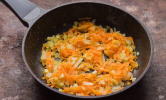 В сковородке разогрейте растительное масло и сначала обжарьте лук, затем добавьте натертую морковь и обжарьте до мягкости. Зажарку сразу переложите к супу.