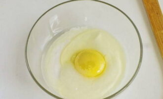 В пиалу выкладываем сметану и ½ чайной ложки соли, разбиваем яйцо.