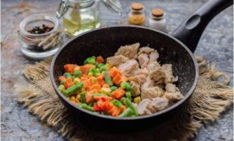 В сковороде раскаляем небольшое количество подсолнечного масла и выкладываем овощи и мясную составляющую. 