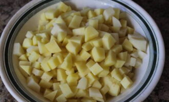 Очищаем картофель, промываем его и нарезаем небольшими кубиками.