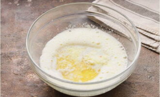 Фрукты перекладываем к яичной смеси, также добавляем растопленное в микроволновой печи или на водяной бане сливочное масло.