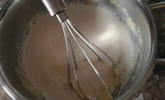 Немного подогрейте молоко и постепенно вылейте половину в тесто.