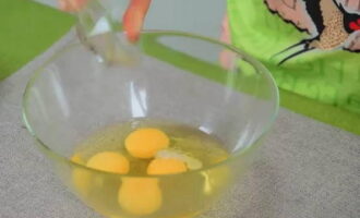 Куриные яйца достаньте из холодильника, промойте и просушите, а затем разбейте в большую емкость. Подсолите и подсахарите.