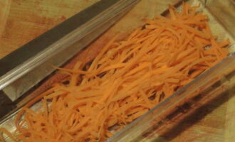 Почистите и промойте морковь. Ее измельчите либо ножом, либо на специальной терке, чтобы получилась тонкая соломка.