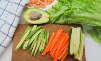Очищенную морковь с огурцом и авокадо хорошо промойте, салфеткой обсушите, и нарежьте тонкой соломкой.