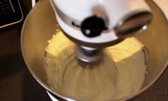 Для крема в чашу миксера поместите холодную сметану, добавьте сахар и при постепенном увеличении скорости взбейте их в густую пышную массу.