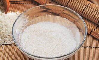 Запеченные роллы легко можно приготовить в домашних условиях. 180 грамм круглого риса высыпаем на сито и старательно промываем под струей воды не менее 3-4 минут.