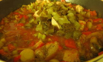 Мясо переложите в овощной соус. Соленые огурцы порежьте и отправьте следом. Готовьте минут 25.