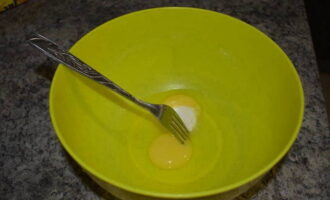 В глубокую миску разбиваем куриные яйца. Добавляем к ним немного соли и сахара по вкусу. Взбиваем вилкой или венчиком до однородной смеси.