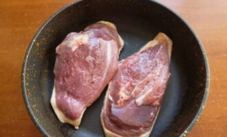 Укладываем мясо шкуркой вниз на сухую холодную сковороду и обжариваем с обеих сторон до образования аппетитной корочки светло-коричневого оттенка.