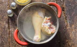 Промытые кусочки курицы отвариваем 30 минут в кипящей воде. После курицу извлекаем из бульона и остужаем.