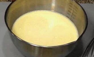 Смешайте молоко с водой. Половину жидкости вылейте к яйцам и добавьте кефир.