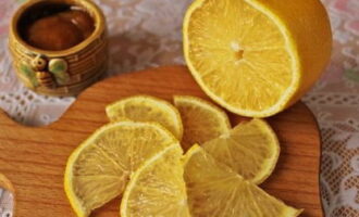 Лимон промойте и просушите. Цитрус порежьте тонкими ломтиками.