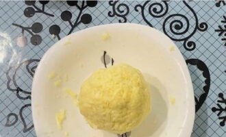 В момент, когда тесто практически подошло, натираем сыры и смешиваем с сырым яйцом, формируем шарик. Горсть измельченного сыра оставляем для верхушки.