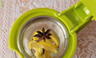 Возьмите заварочный чайник. Сложите лимонные дольки, измельченный имбирь, кардамон и бадьян. Насыпьте чай зеленый или черный на ваше усмотрение.