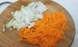 Рис с овощами на сковороде готовится очень просто. Овощи для блюда сразу почистите и промойте. Часть овощей можно взять замороженных. Луковицу нарежьте небольшими кубиками. Морковь измельчите на крупной терке.