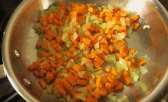 Когда лук доведете до прозрачности, добавьте нарезанную кубиками морковку и измельченный чеснок.