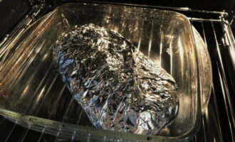 Запечатайте мясо фольгой, сложите в форму. Прогрейте духовку до 180 градусов. Уберите мясо в духовку.