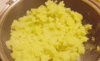 Отварной картофель протрите через сито или пропустите через пресс. Подсушите протертый картофель в сотейнике. Сдобрите сливочным маслом и вылейте прогретое молоко. Тщательно промешайте венчиком.