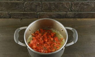 В кастрюлю с хорошо протушенным мясом выкладываем мякоть помидоров, соль, специи и томатную пасту.