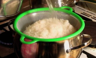 В кастрюле для варки риса доведите до кипения 2 стакана чистой воды. В кипящую воду пересыпьте промытый рис, насыпьте соль, все перемешайте и поварите его на небольшом огне 15-17 минут от начала кипения. Попробуйте рис на готовность и поварите еще 5 минут под прикрытой крышкой,  периодически помешивая. Отваренный рис откиньте на дуршлаг и промойте кипятком.