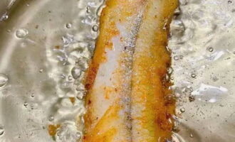 Когда снизу образуется аппетитная корочка, разверните рыбу румяной стороной вверх.
