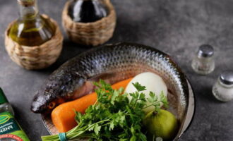 Возьмите все необходимые ингредиенты для приготовления пеленгаса. Морковь и лук очистите, помойте вместе со свежей зеленью под проточной водой.