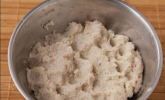 Очистите и натрите на мелкой терке одну крупную картошку. Сок слейте. Добавьте картофель к рыбно-луковому фаршу и по своему вкусу насыпьте соль с черным перцем. Руками фарш хорошо вымесите до однородного состояния.