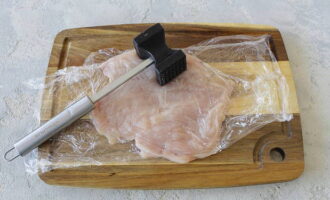 Кусок мяса накройте пленкой и тщательно отбейте молоточком. Посыпьте солью и перцем и вотрите специи.