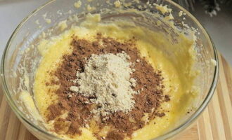 В получившуюся массу просейте какао-порошок, молотый имбирь, корицу и мускатный орех. Размешайте лопаткой.