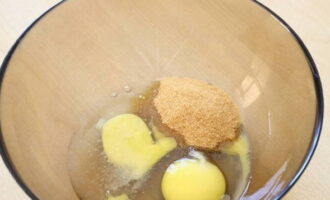 В другую емкость разбейте куриные яйца, всыпьте соль и сахар. 