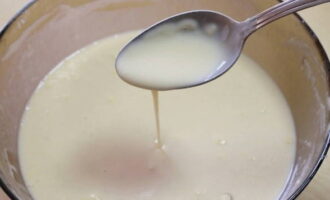 Молоко влейте в небольшой сотейник и доведите до кипения. Введите молоко в тесто, параллельно перемешивая тесто ложкой.