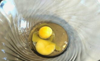 В глубокую миску разбиваем куриные яйца.