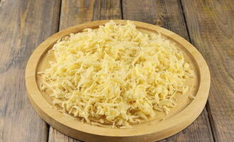Отмеряем необходимый кусок сыра и натираем его на крупной терке. Рекомендуется выбирать несоленый сорт сыра.