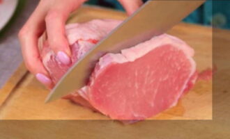 Подмороженный кусок свиной мякоти нарезаем пластинками. Примерная толщина ломтиков – 1 см.