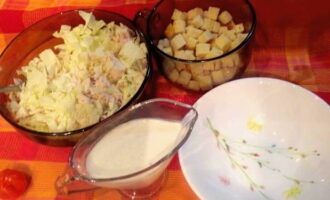 Солим салат и перемешиваем его.  Раскладываем салат по сервировочным тарелкам и дополняем сухариками.