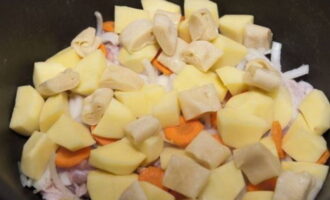 Выкладываем ингредиенты слоями в казан: мясо, лук, морковь, картофель, кусочки теста. Повторяем слои.