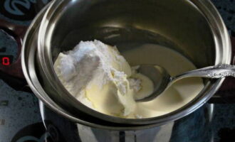 В сотейник отправляем жирные сливки, сливочный сыр и меньшую часть сахарной пудры. Перемешиваем продукты и ставим заготовку на водяную баню. Готовим 3-5 минут после нагревания, постоянно помешивая. Как только масса станет однородной, снимайте ее с бани и дайте немного остыть.