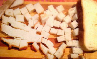Батон нарезаем небольшими кубиками. Подсушиваем их в духовке для получения румяных сухариков.