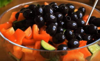 Нарезку овощей переложите в глубокую салатницу, добавьте к ним банку маслин без косточек и овощи аккуратно перемешайте.