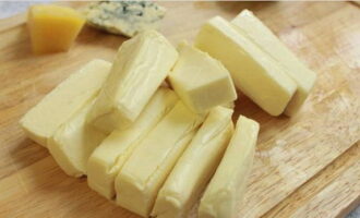 На довольно крупные сегменты разрезаем плавленый сыр.