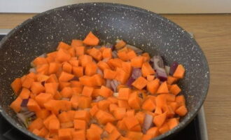 Ставим сковородку на плиту и прогреваем, предварительно наливаем растительное масло. Перекладываем морковку и лук. Пассеруем, периодически переворачивая нарезку, пока морковка не размягчится.