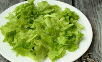 На блюде для подачи распределяем предварительно измельченные листья салата.