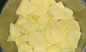 Картофель почистить, промыть, нарезать тонкими ломтиками и перемешать с солью.