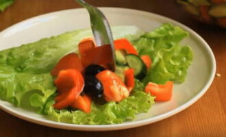 На сервировочные салатницы уложите промытые листья зеленого салата. На них разложите микст овощей.