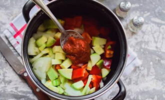 Подготовленную нарезку переложите в толстостенную посуду для варки. Посолите и посахарите. Влейте растительное масло и воду. Добавьте томатную пасту.
