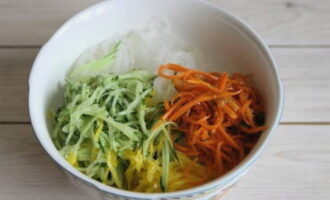 Соедините лапшу, овощную нарезку и морковку по-корейски. Морковку по-корейски можно использовать собственного приготовления или магазинную. Если надумаете готовить самостоятельно, сделайте это заранее. Полуфабрикат должен настояться.