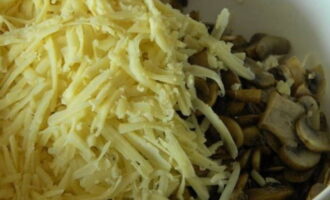 Поверх теплых грибов выложить натертый сыр и все активно перемешать, чтобы сыр немного расплавился.